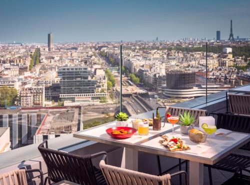 a table on a balcony with a view of a city at Melia Paris La Defense in Courbevoie