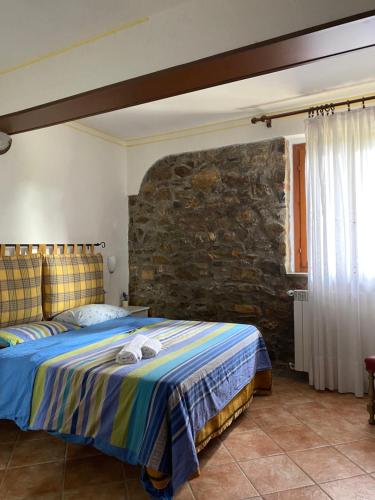 1 dormitorio con cama y pared de piedra en Agribike Agriturismo Poggio Rossino, en Gavorrano