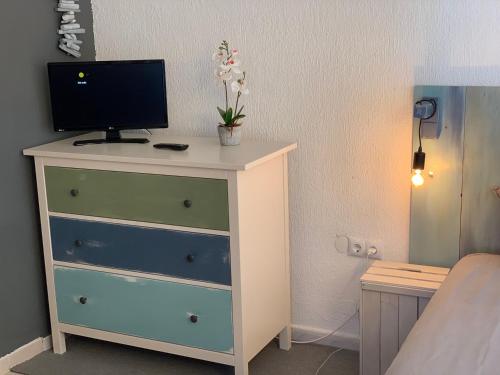 a bedroom with a dresser with a television on it at Apartamentos RG Resitur in Seville