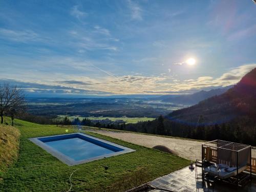 a swimming pool on top of a grassy hill at Berghotel & Chalets Adersberg Chiemgau Card kostenfrei in Grassau