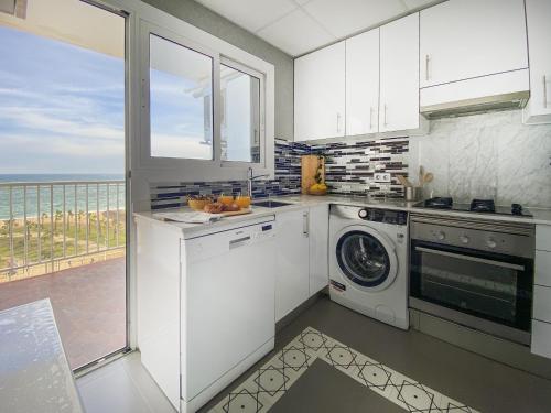 a kitchen with a washing machine and a window at fantasticas vistas a mar in Pineda de Mar