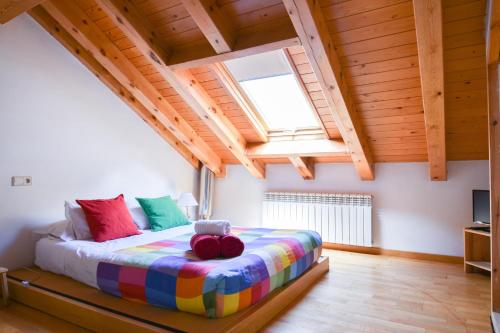 ein Schlafzimmer mit einem Bett mit bunten Kissen in der Unterkunft Ca La Rougvie in Esterri d'Àneu