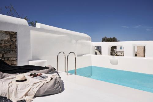 a table with a hat sitting on a balcony next to a pool at Casa Bo Private Pool in Mýkonos City