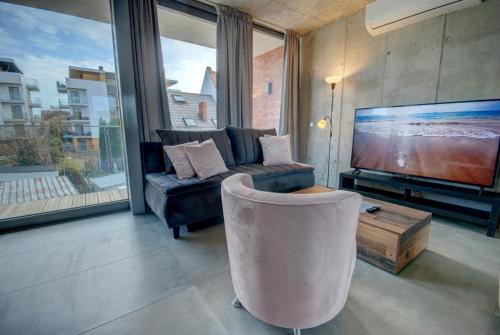 a living room with a couch and a tv at HelApart - Loft in Hel