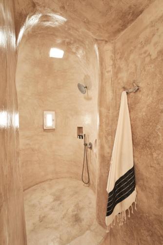 a bathroom with a shower with a towel on a wall at Casa Bo Private Pool by Monocle in Vrisi/ Mykonos