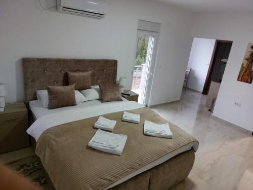 a bedroom with a large bed with towels on it at Apartmani Marija in Vrdnik