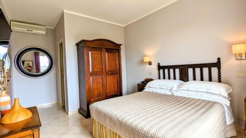 a bedroom with a bed and a wooden cabinet at Arts Club Suite & Spa in Chianciano Terme