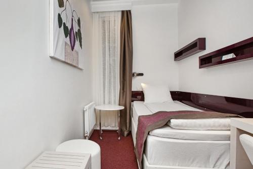 a small room with two beds and a window at Ibis Styles Stockholm Odenplan in Stockholm