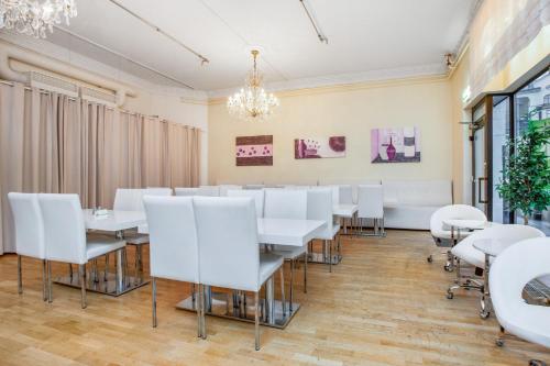 a dining room with white tables and chairs at Ibis Styles Stockholm Odenplan in Stockholm