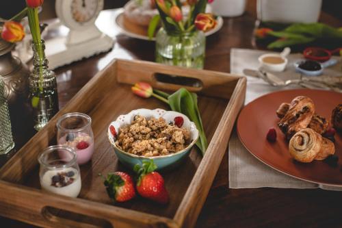a wooden tray with a bowl of cereal and strawberries on a table at Relais Almaranto in Calamandrana