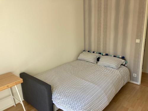 a small bedroom with a bed with a blue headboard at Appartement T3 centre ville Mabilais au calme. in Rennes