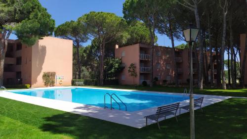 a swimming pool in a yard with trees and a building at Bonito apartamento, con piscina, excelente wifi y aire acondicionado in Pals