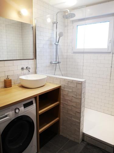 a bathroom with a sink and a washing machine at Appartement T3 centre ville Mabilais au calme. in Rennes