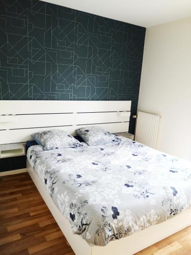 1 dormitorio con cama y pared verde en Appartement T3 centre ville Mabilais au calme. en Rennes