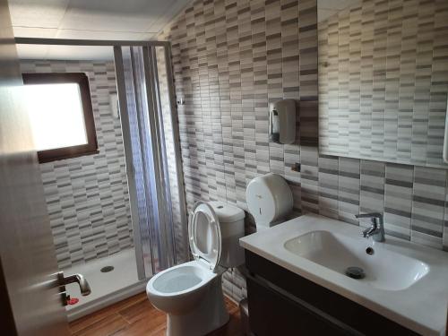 a bathroom with a toilet and a sink at El Castillo de Moratinos in Moratinos