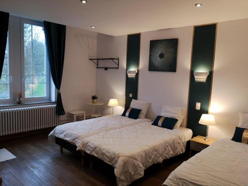a hotel room with two beds and two windows at Le Manoir de la Rulette 20P well-ness BBQ Jardin terrasse ping pong salle de jeux in Tintigny