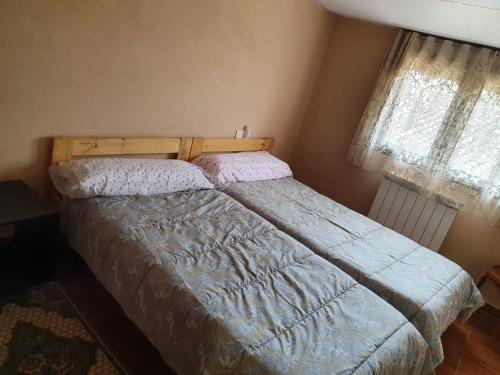 a bedroom with a bed with a blue comforter at El Castillo de Moratinos in Moratinos