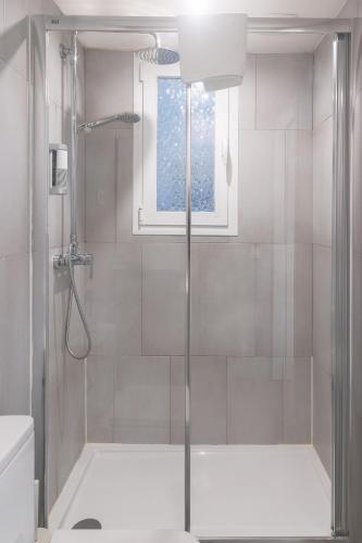 a bathroom with a shower and a window at Vibe Apartments by Olala Homes in Hospitalet de Llobregat