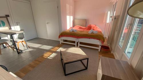 a small bedroom with a bed and a table at The 105 - Stunning new studios by the lake, close to city center of Lausanne in Paudex