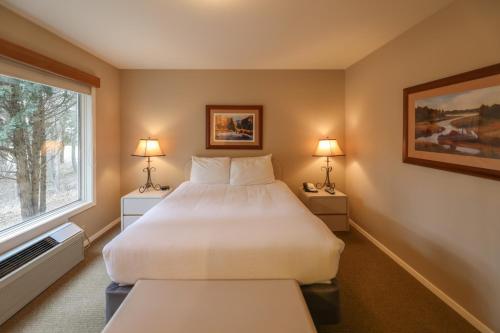 a bedroom with a large bed and a window at Meadow Lake Resort & Condos in Columbia Falls