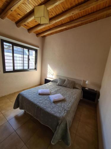 1 dormitorio con 1 cama con 2 toallas en CASA TUNUYÁN en Tunuyán