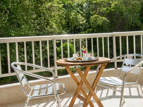 a wooden table and two chairs on a balcony at Hotel Eden in Nei Poroi