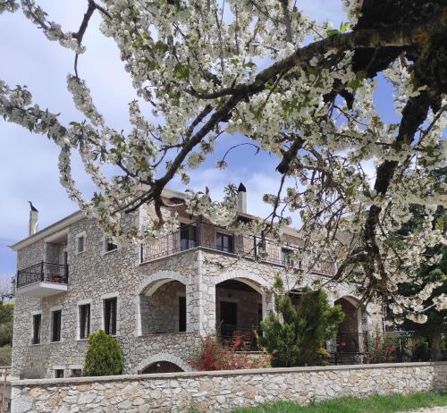 - une vue sur l'extérieur d'une maison en pierre ornée de fleurs blanches dans l'établissement Ouranogiton Resort, à Kosmas