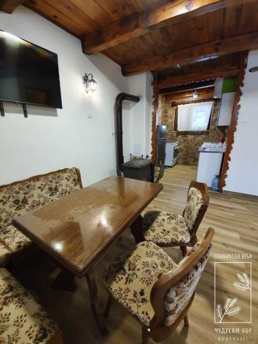 a dining room with a wooden table and chairs at Planinska kuća Čudesni bor in Divčibare