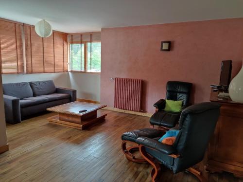 a living room with a couch and a table at LES GÎTES CELTIQUES DU PÈRE NICOLAS in Plumeliau Bieuzy