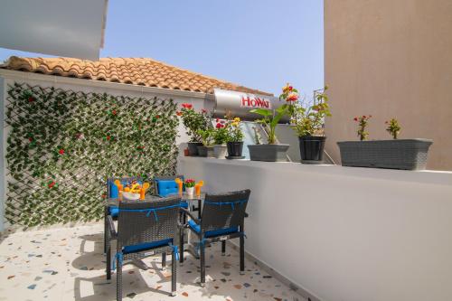 a patio with two chairs and a counter with plants at Alkeos Suite in Zakynthos Town