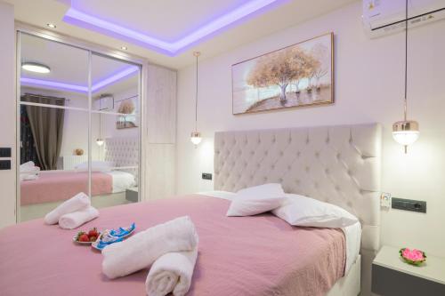 una camera da letto con un letto rosa con asciugamani sopra di Alkeos Suite by "elite" a Città di Zante