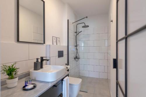a white bathroom with a sink and a shower at The Easy Rooms Terrace in Antalya