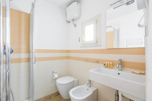 a bathroom with a toilet and a sink and a mirror at Palazzo Montalbano in Scicli