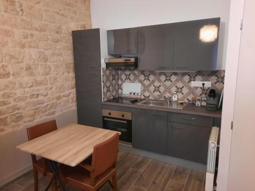 eine kleine Küche mit einem Holztisch und einem Waschbecken in der Unterkunft Gîtes de la mousseterie in Échiré
