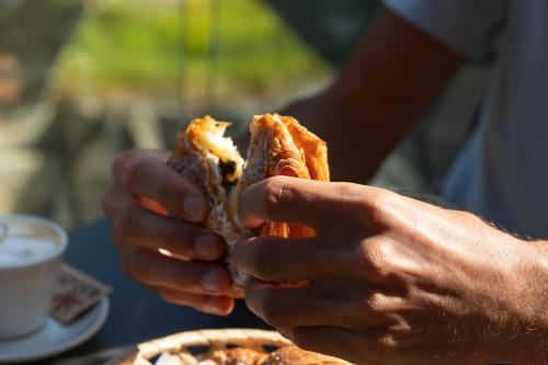 a person holding a sandwich in their hands at La Cascata Chambres d'hôtes in La Salle