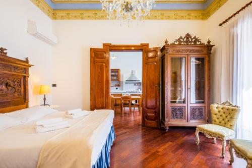 a bedroom with two beds and a chandelier at Palazzo Montalbano in Scicli