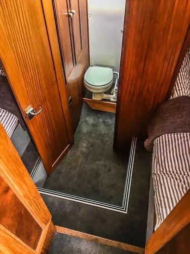 a small bathroom with a toilet and a bed at Motor Yacht Sea Wolf in Lymington