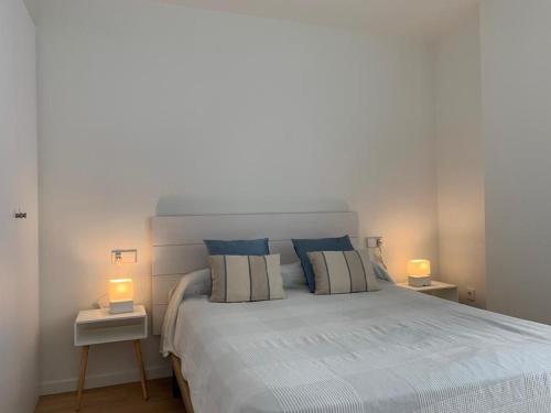 a bedroom with a large bed with two lamps on tables at Apartamento Botánico, Centro de Granada in Granada