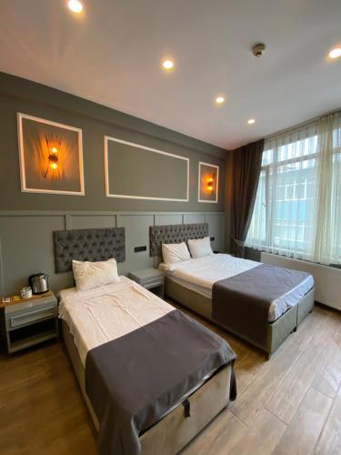a bedroom with two beds and a large window at Ortakoy Aysem Sultan Hotel in Istanbul