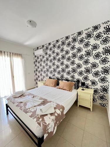 a bedroom with a bed with a black and white wallpaper at Nautica Hotel Apartments in Stavromenos