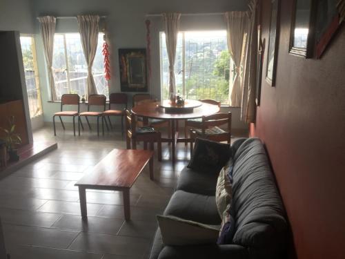 a living room with a couch and a table and chairs at Otentik guesthouse in Mbabane