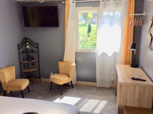 una camera da letto con un letto, due sedie e una finestra di bienvenue chez Alain et Marie a Antibes