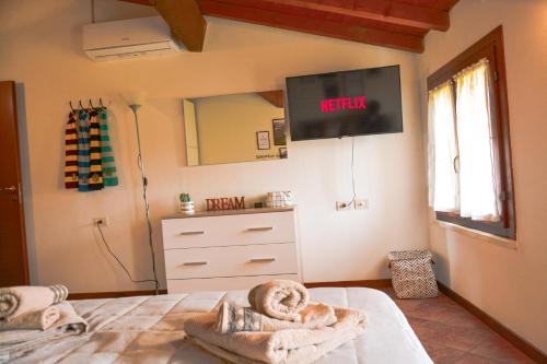 a bedroom with a bed with a tv on the wall at Il Paiolo Magico in Valeggio sul Mincio
