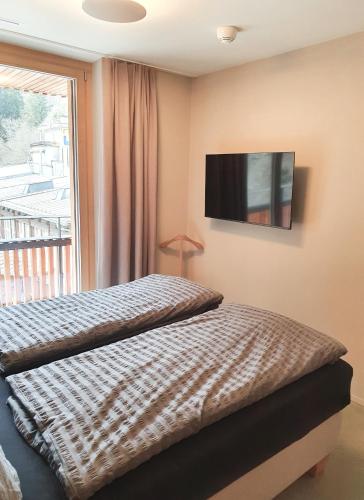 a bedroom with a bed and a television on the wall at Ferienwohnung Stenna SELVA an Toplage in Flims