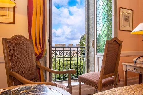 a room with a window with a view of a balcony at Hotel de la Cité Carcassonne - MGallery Collection in Carcassonne