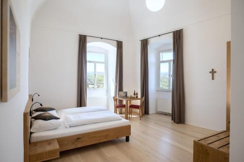 ein Schlafzimmer mit einem Bett und einem Kreuz an der Wand in der Unterkunft Gästehaus Benediktinerstift Göttweig - Bed & Breakfast Monastery in Furth
