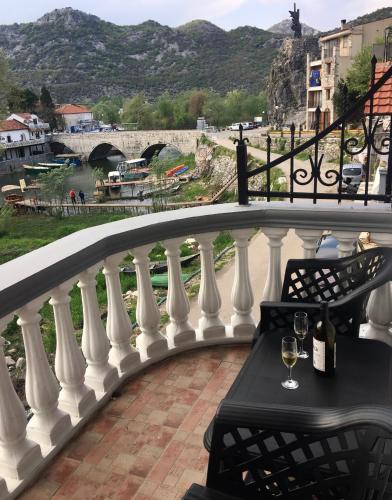 a balcony with a table and a wine glass at Apartments FLORA and boat cruising in Virpazar