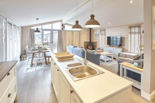 a kitchen with a sink and a living room at Host & Stay - Puffins Rest in Runswick