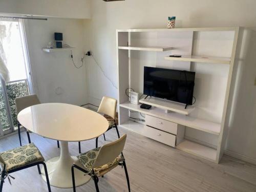 sala de estar blanca con mesa y TV en departamento ideal en belgrano en Buenos Aires