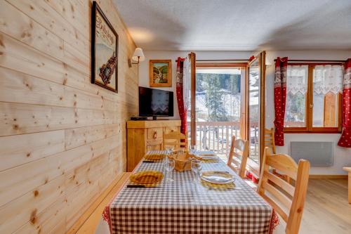 une salle à manger avec une table et une télévision dans l'établissement La Loutre, à La Giettaz